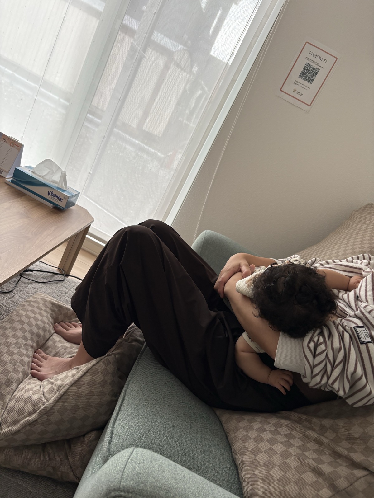背中にクッションを当て、赤ちゃんを身体に密着させて授乳している様子を横から見たところ